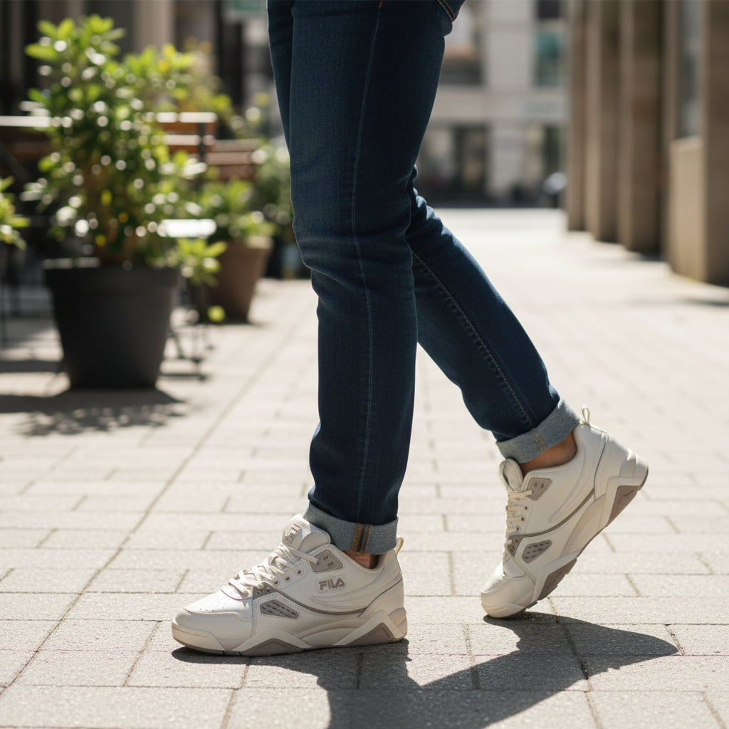 Homme portant baskets Fila Casim beige, jeans, en extérieur urbain, LA CHAUSSURERIE