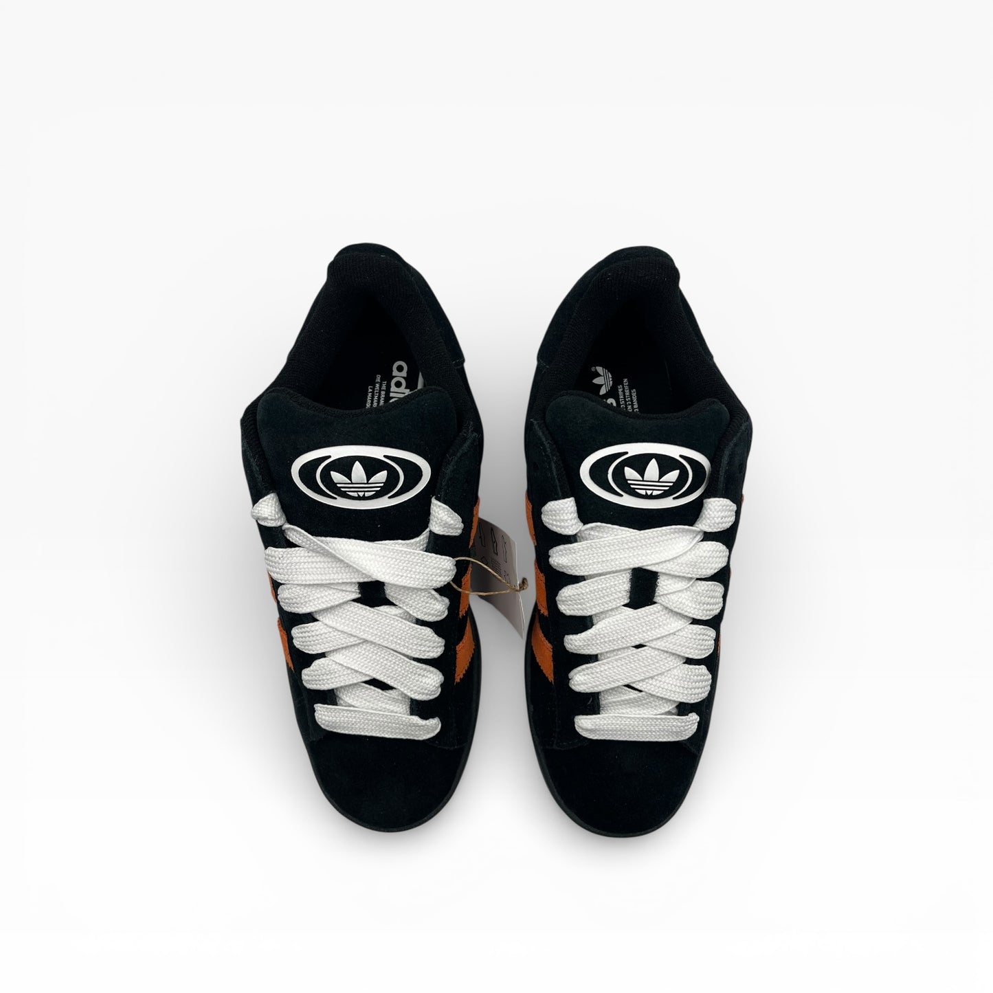 Paire de baskets Adidas noires à bandes orange, lacets blancs, photo pour La Chaussurerie