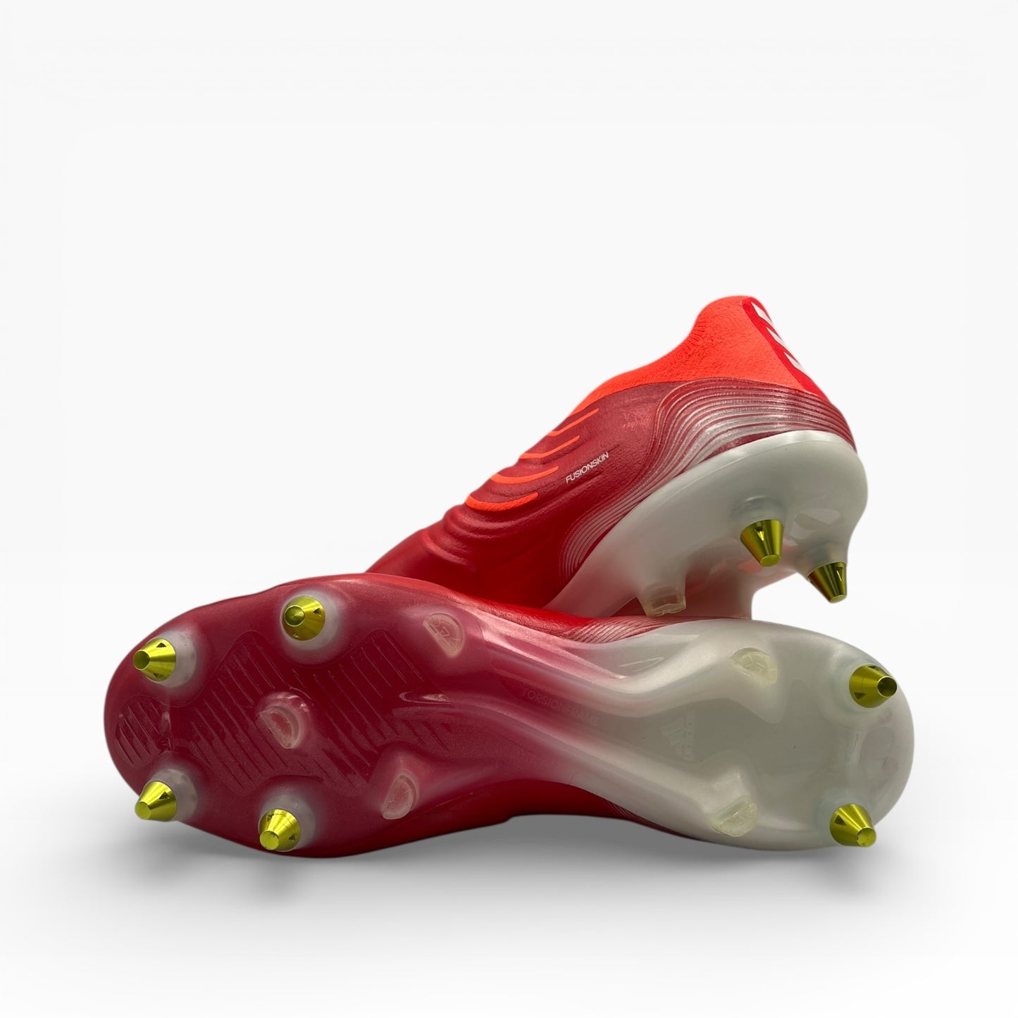 Chaussures de foot à crampons rouges et dorés, semelles visibles, LA CHAUSSURERIE