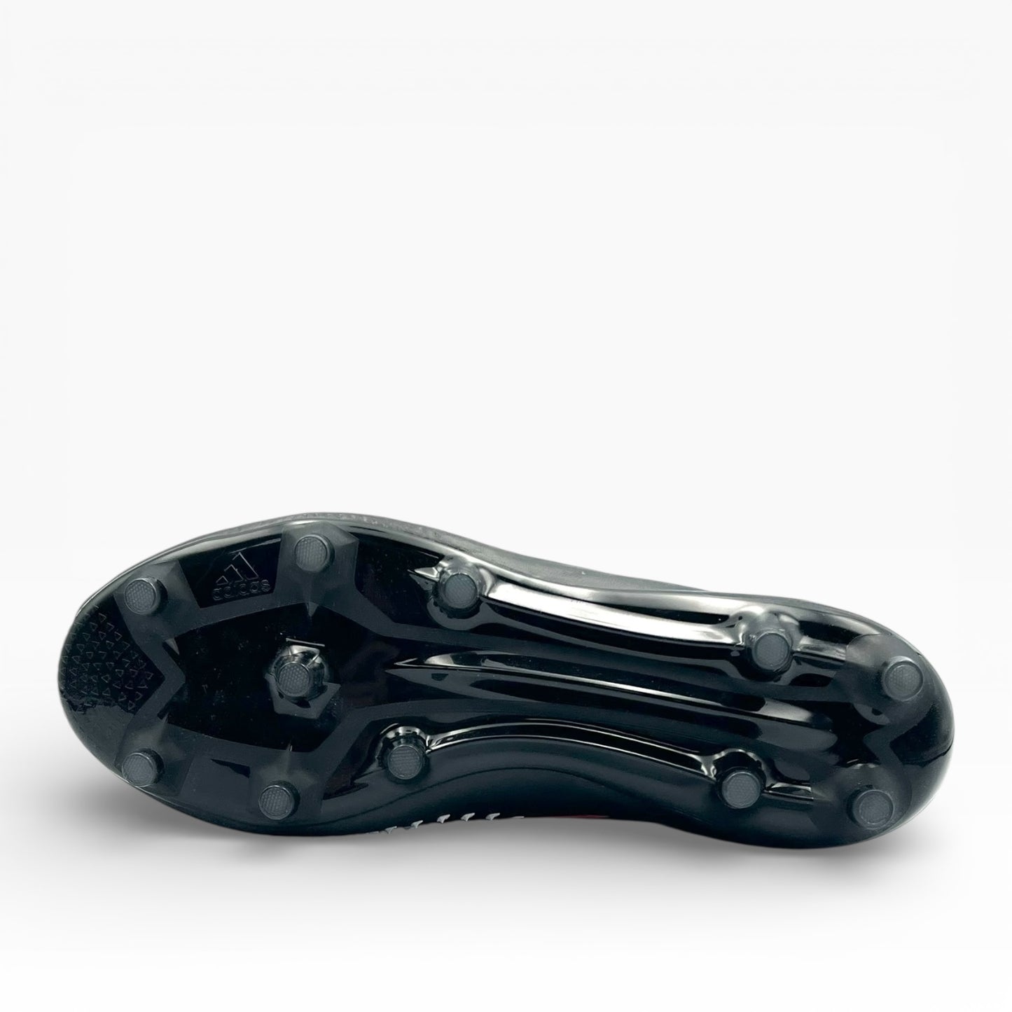 Semelle cramponnée noire de chaussure de football Adidas, vue de dessous, LA CHAUSSURERIE