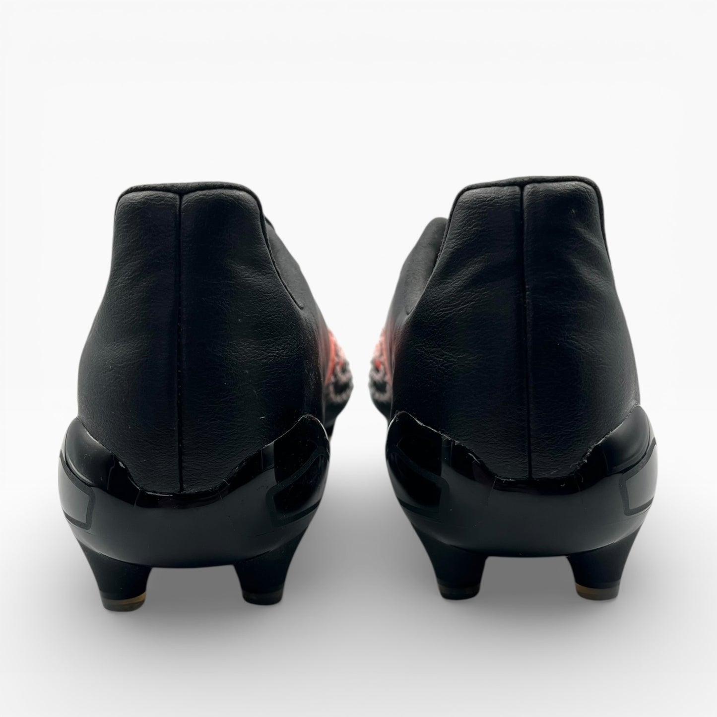 Vue arrière de chaussures à crampons en cuir noir, LA CHAUSSURERIE, fond blanc.