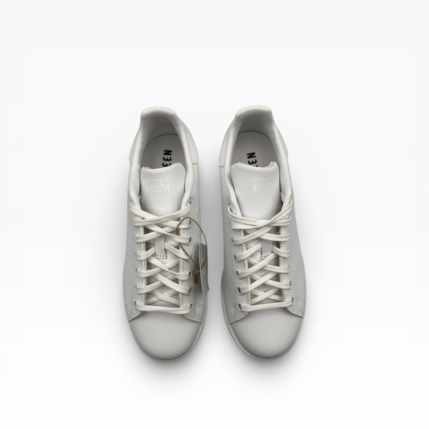 Vu dessus de deux baskets blanches Stan Smith Adidas, lacets visibles, fond blanc, La Chaussurerie