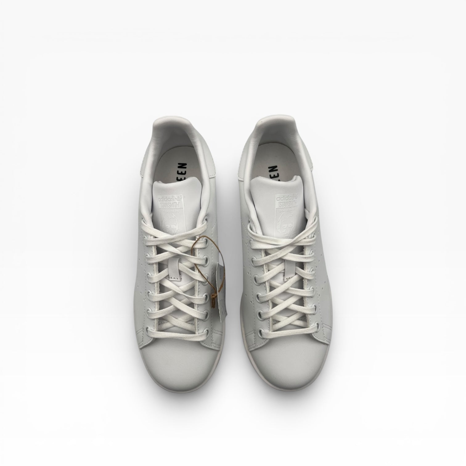 Vu dessus de deux baskets blanches Stan Smith Adidas, lacets visibles, fond blanc, La Chaussurerie